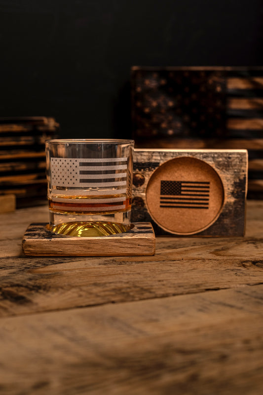 Rocks glass with bourbon barrel wooden coaster featuring an American flag design