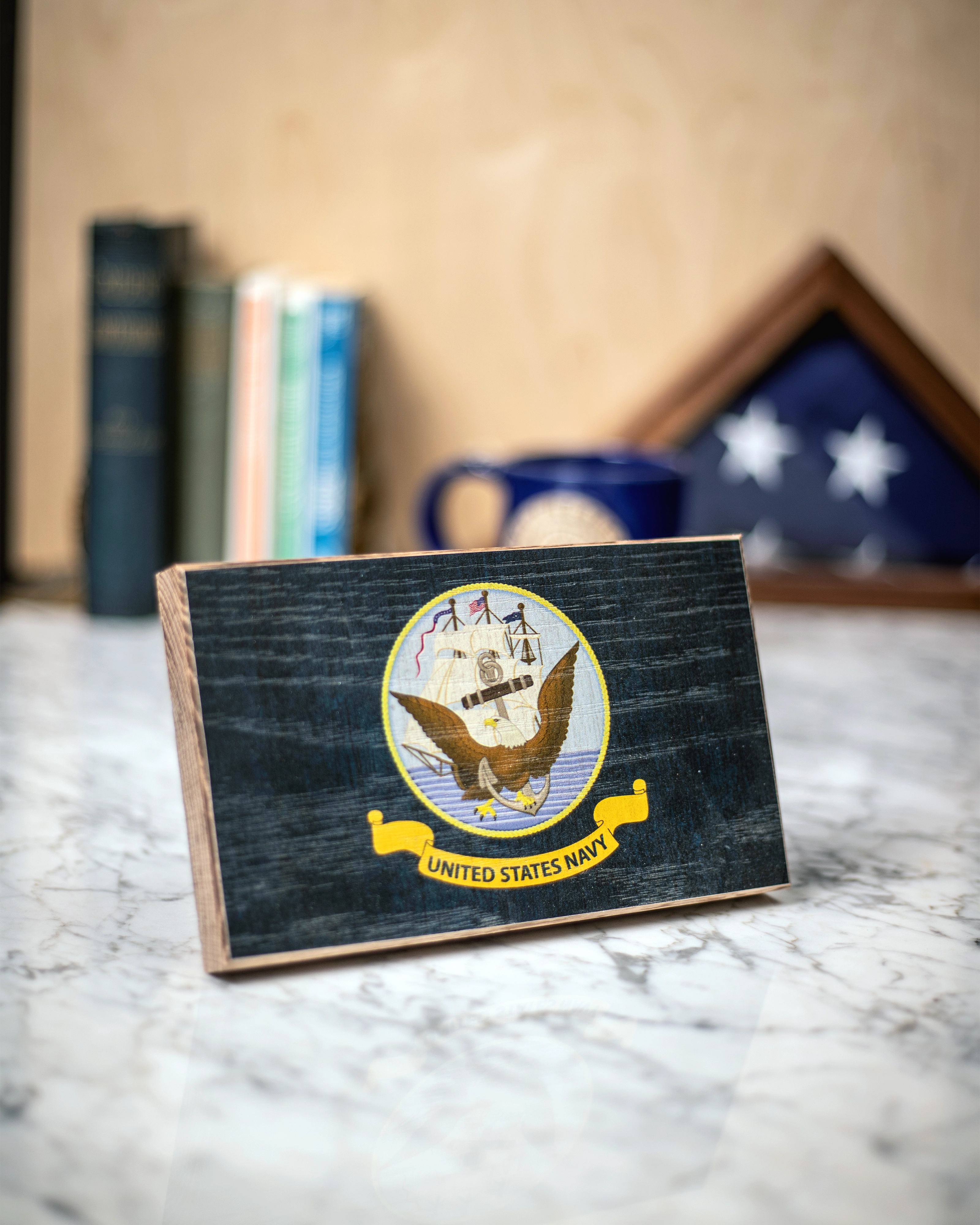 Service Branch Desk Flag featuring United States Navy emblem with books and a mug in the background.