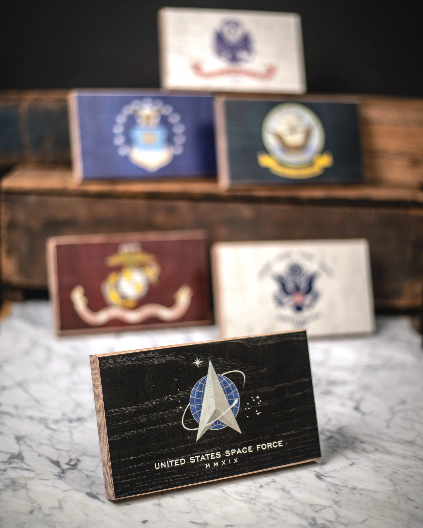 Collection of U.S. military service branch desk flags featuring U.S. Space Force sitting on marble surface.