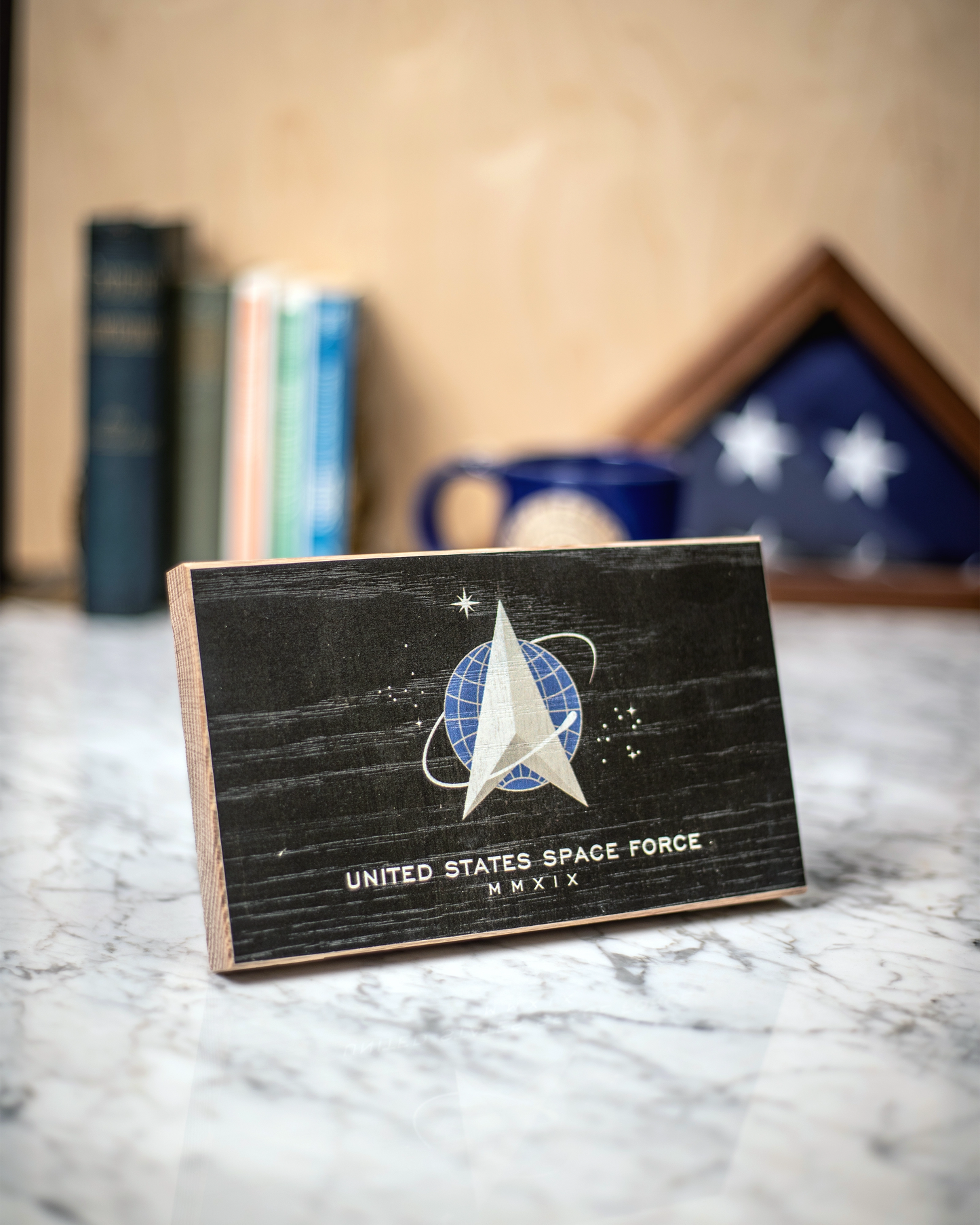 Service Branch Desk Flag featuring United States Space Force emblem with books and a mug in the background.