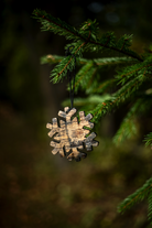 Bourbon barrel snowflake ornament hanging on a tree branch