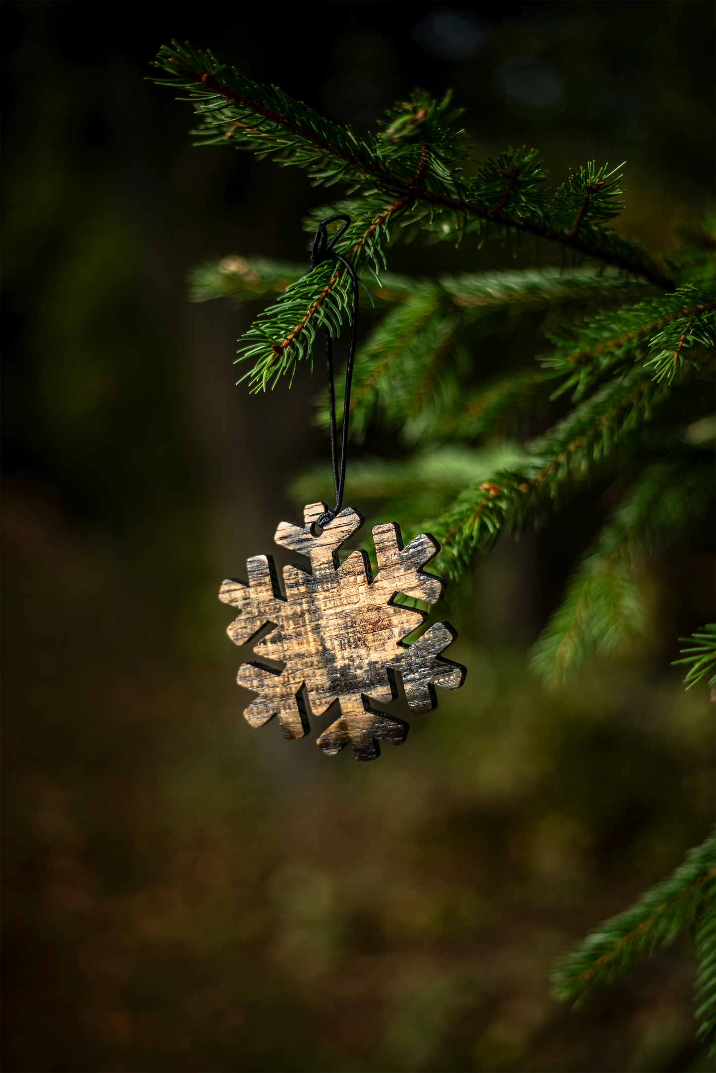 Bourbon barrel snowflake ornament hanging on a tree branch
