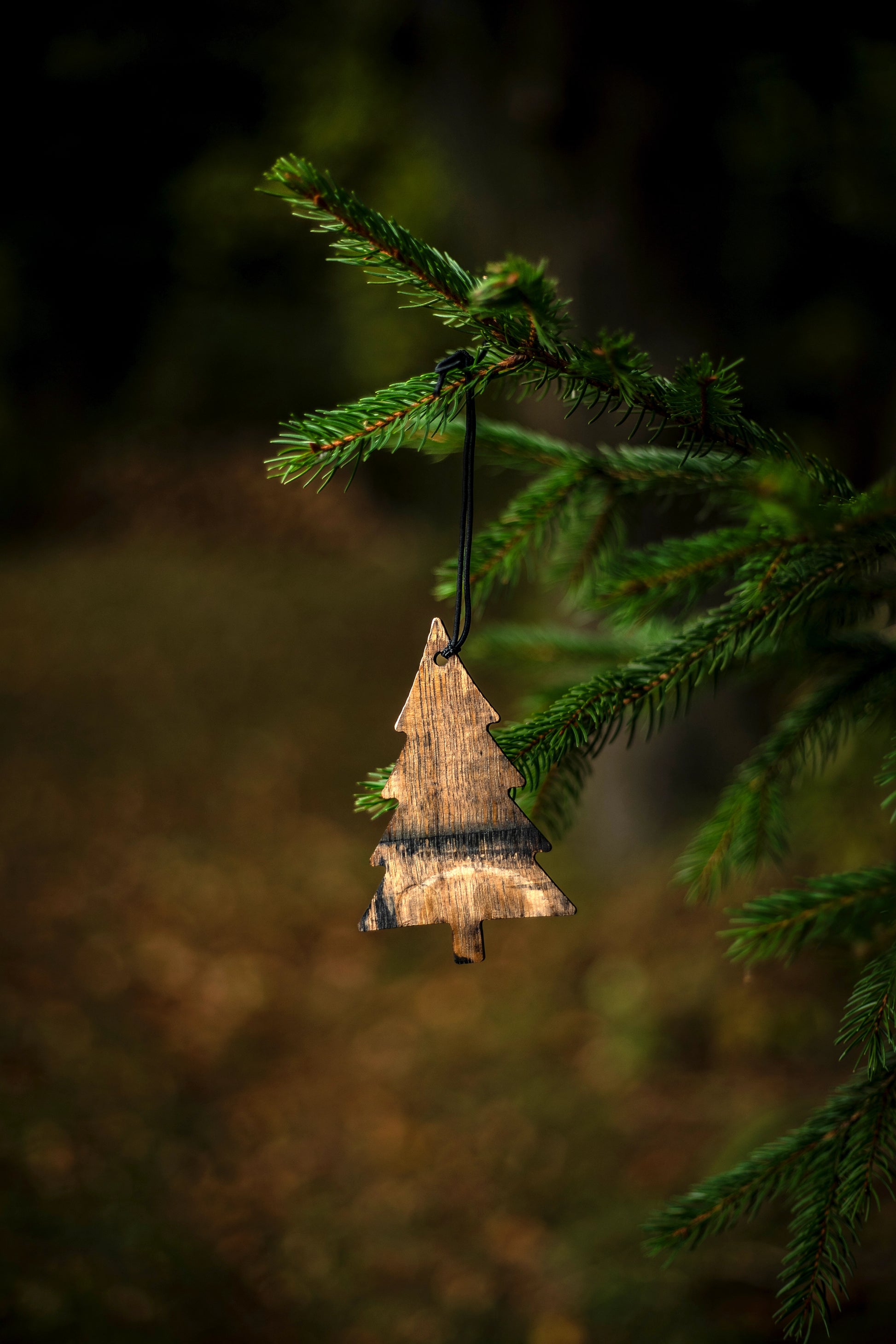 Wooden bourbon barrel Christmas tree ornament hanging on a branch