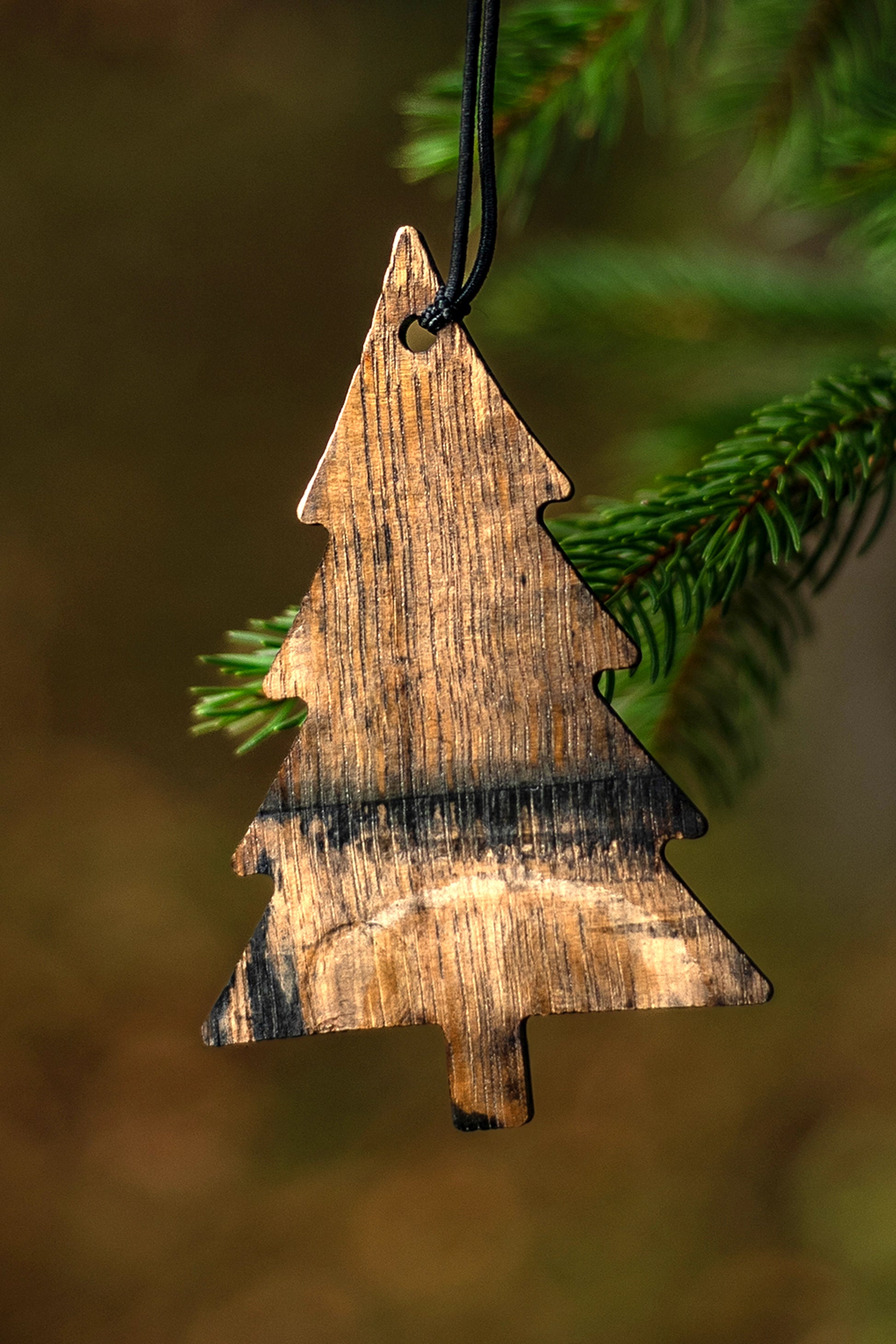 Wooden bourbon barrel Christmas tree ornament hanging on a branch