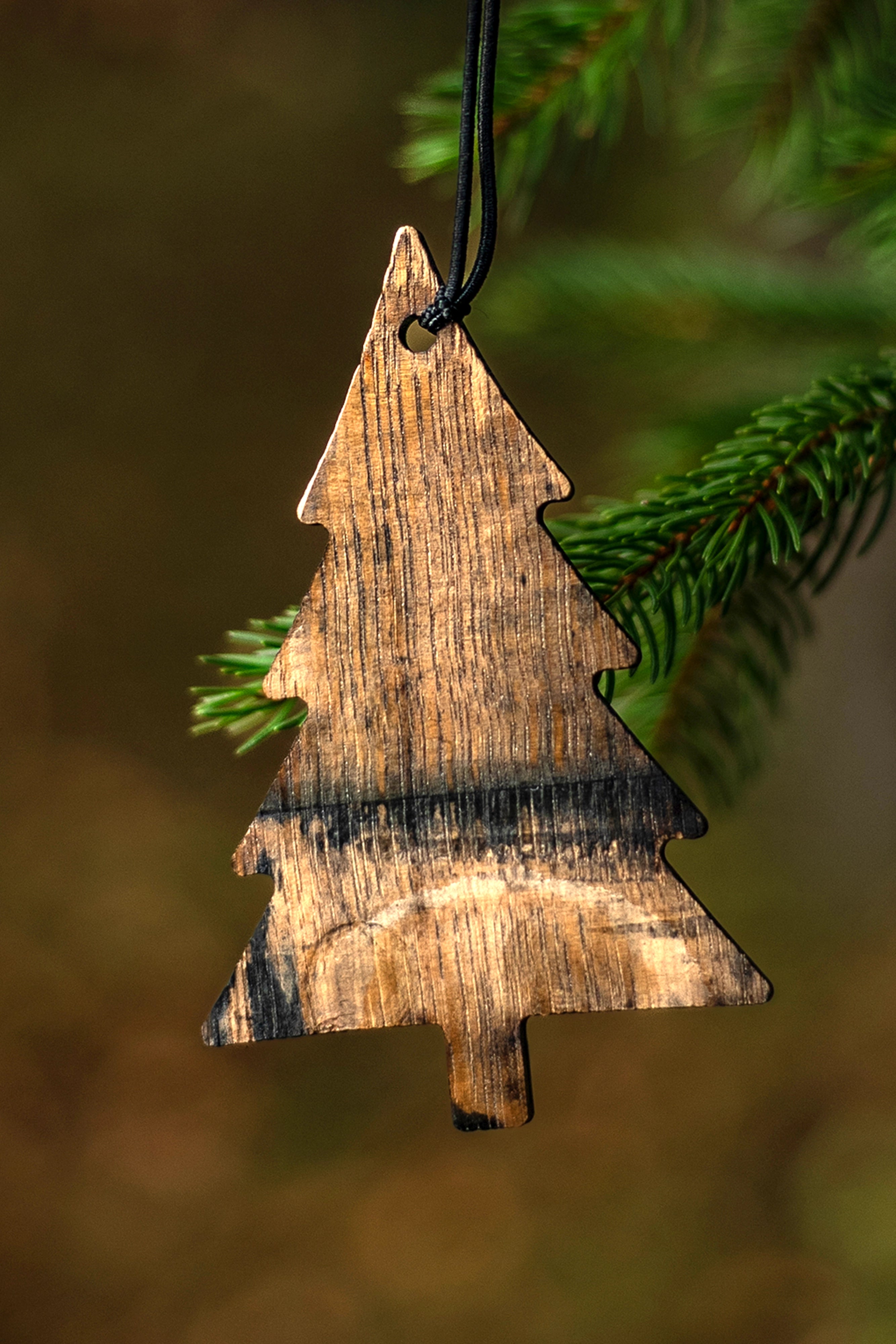 Wooden bourbon barrel Christmas tree ornament hanging on a branch