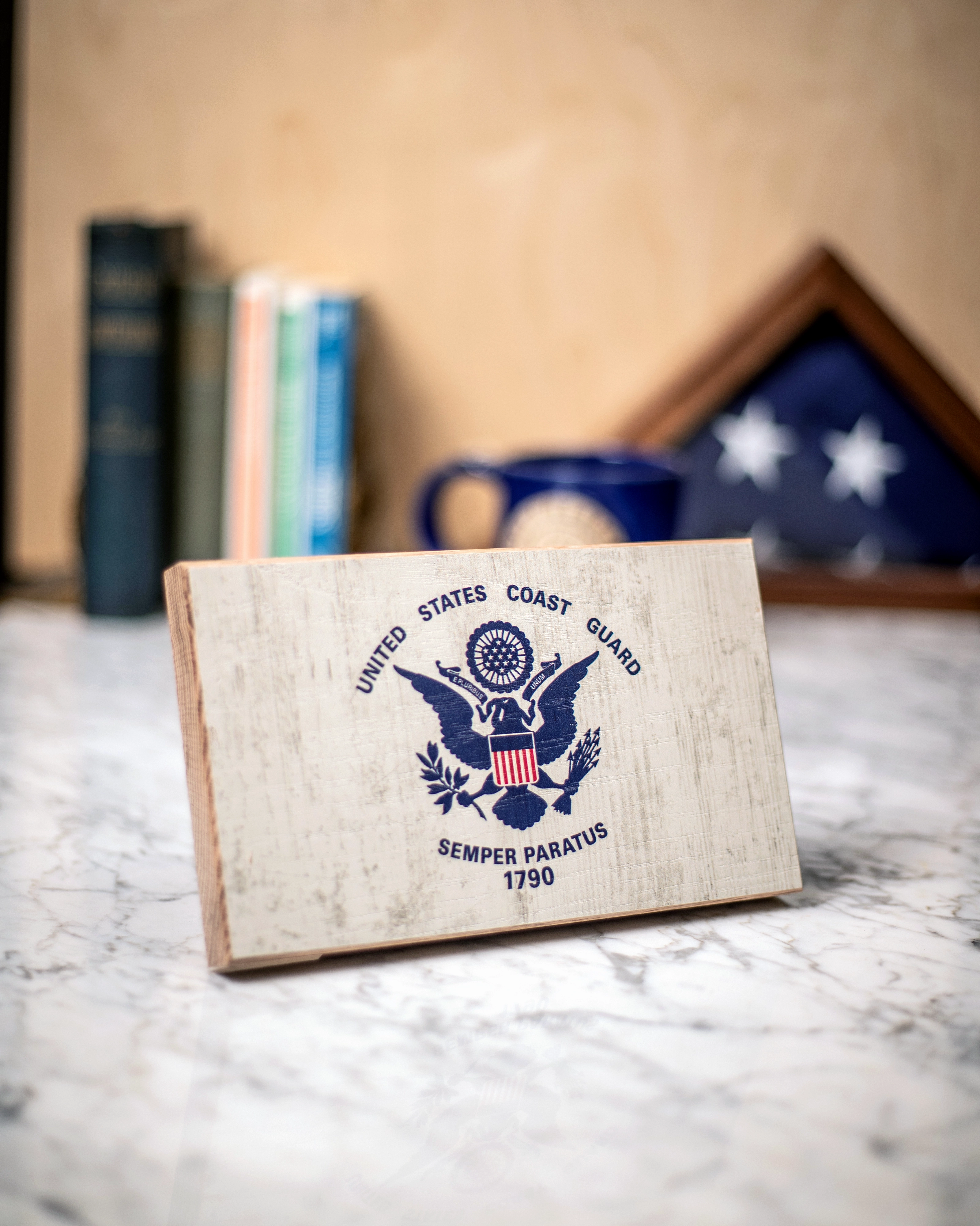 Service Branch Desk Flag featuring United States Coast Guard emblem with books and a mug in the background.